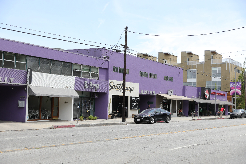 A car parked on the side of a road near buildings.