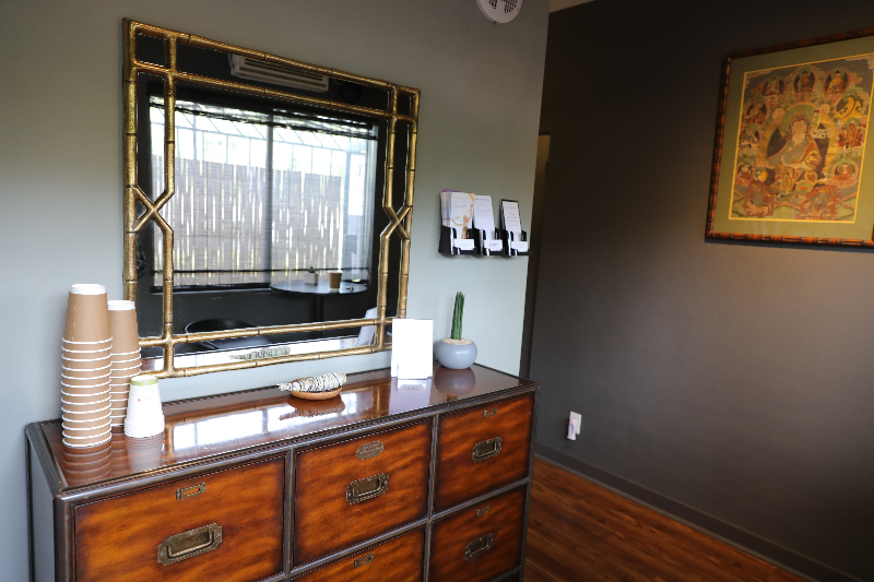 A dresser with drawers and a mirror in the corner.